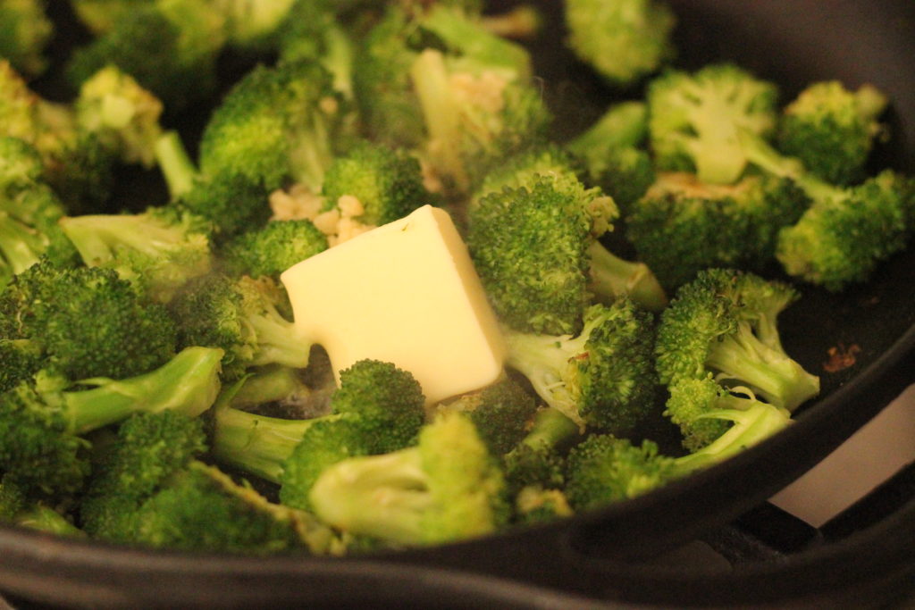  buttered broccoli cooking in a pan with butter