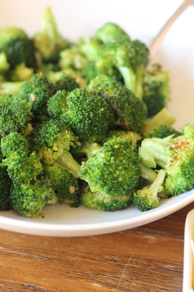 broccoli cooked with butter and garlic in a white bowl