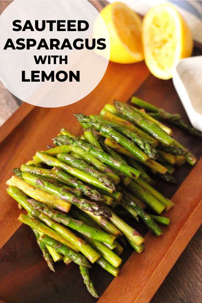 Sauteed asparagus with lemon on a wooden serving plate