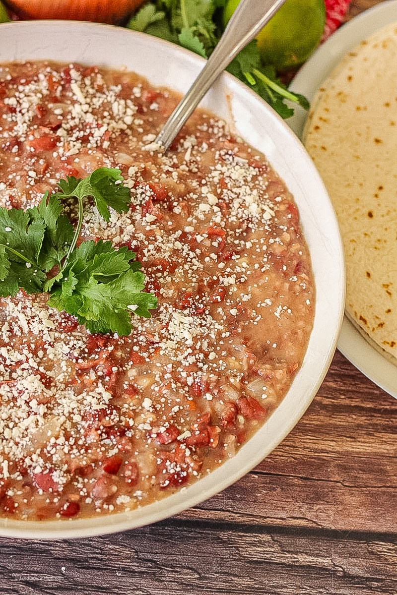 big bowl of refried beans topped with cilantro and cheese