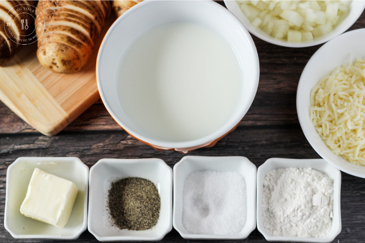 ingredients for scalloped potatoes. Milk, cheese, potatoes, onion, butter, flour and salt and pepper