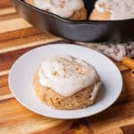 cinnamon biscuits with cream cheese frosting baked in a cast iron skillet