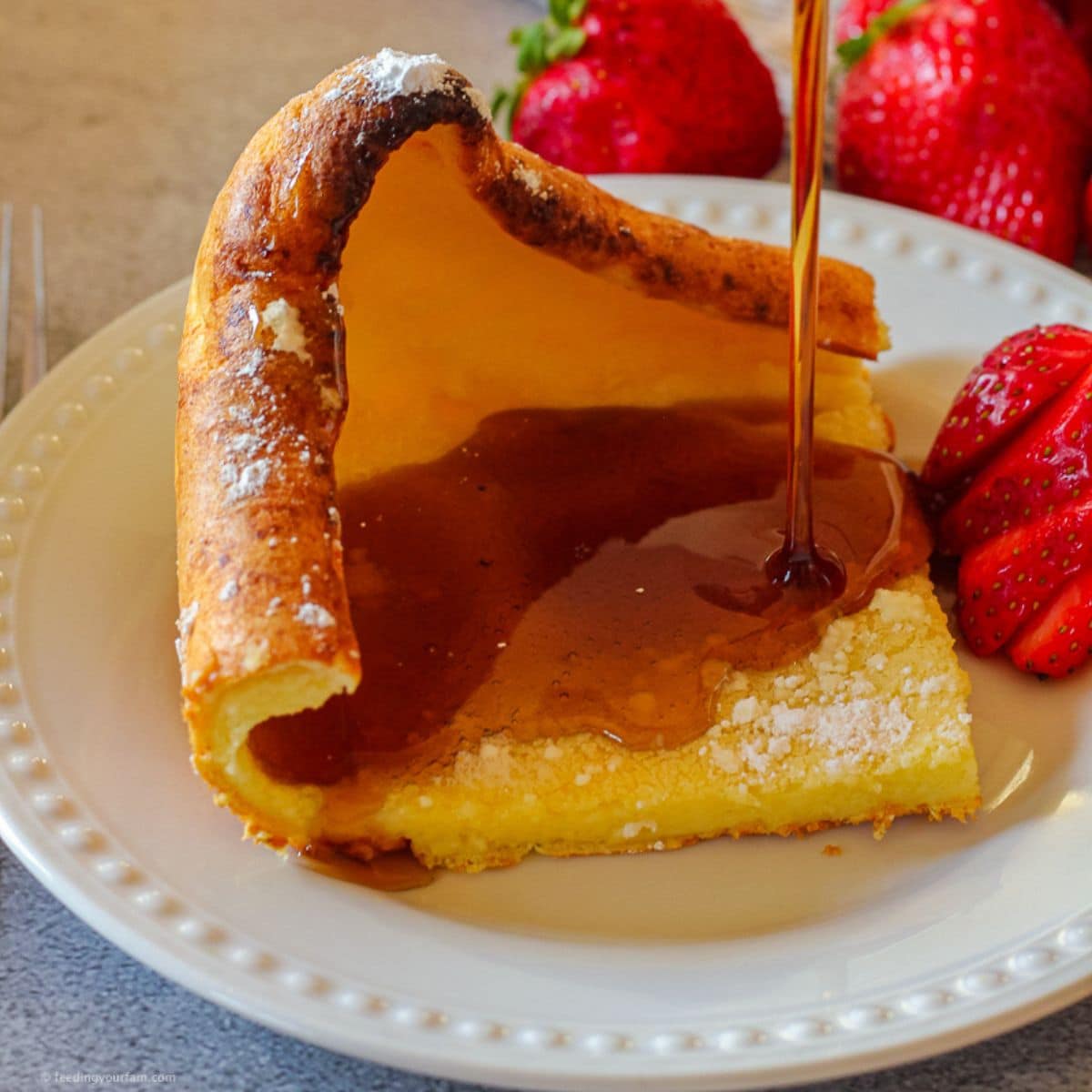 puffy pancake being drizzled with syrup