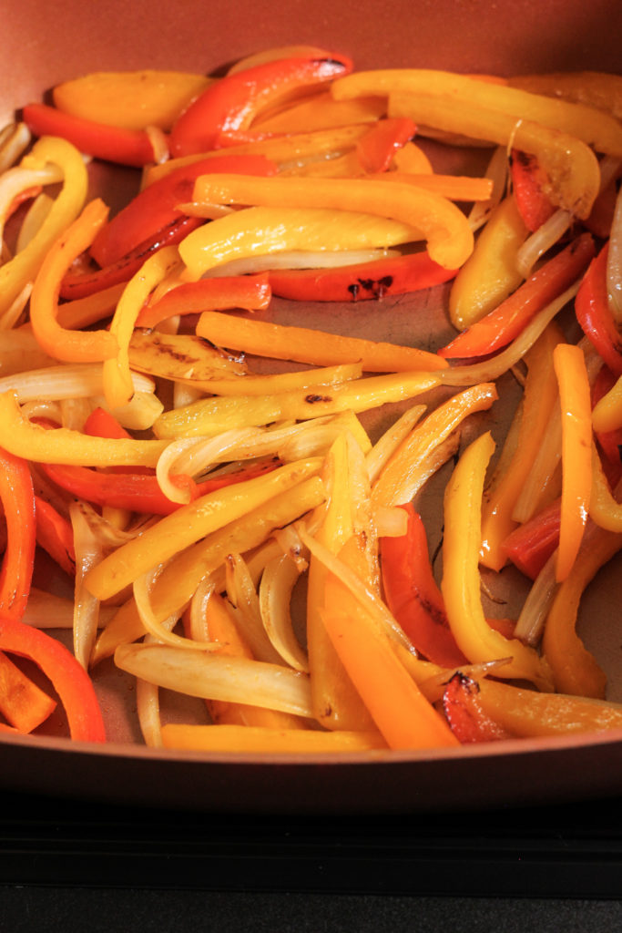 sauteed peppers and onions in a copper pan