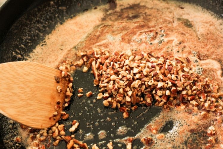 toasting pecans in a cast iron pan in melted butter and brown sugar