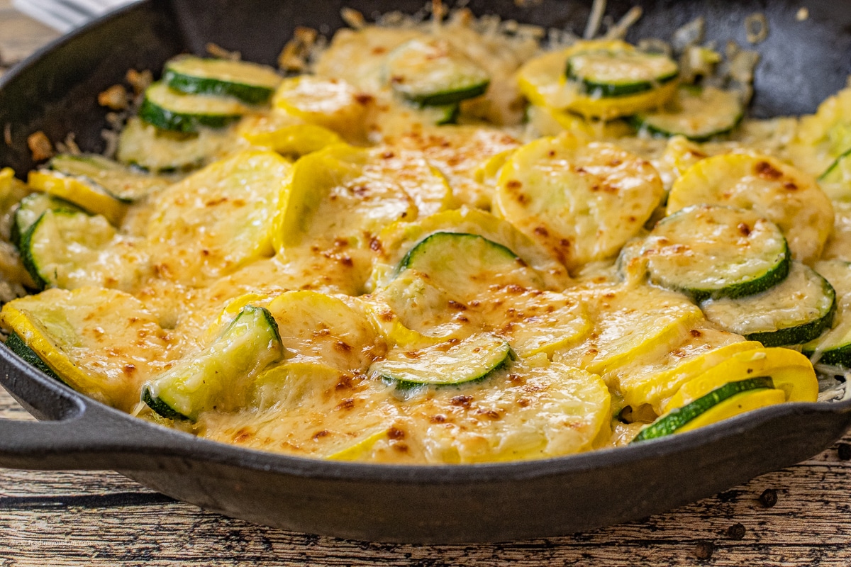 zucchini side dish cooked in a cast iron skillet and topped with parmesan cheese