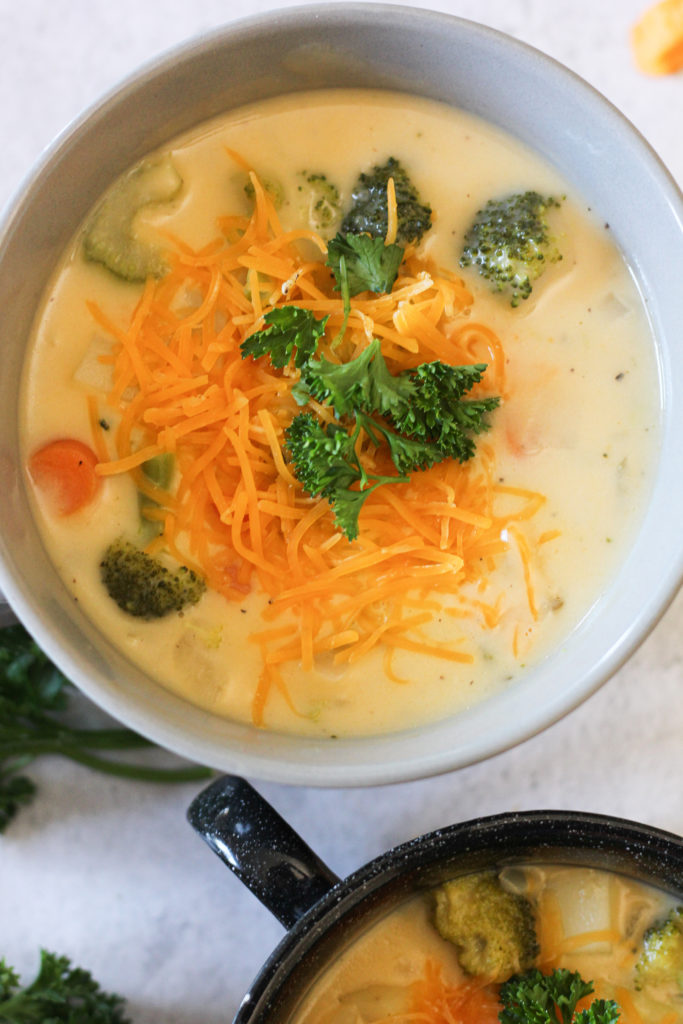broccoli and potato cheese soup topped with cheese and parsley