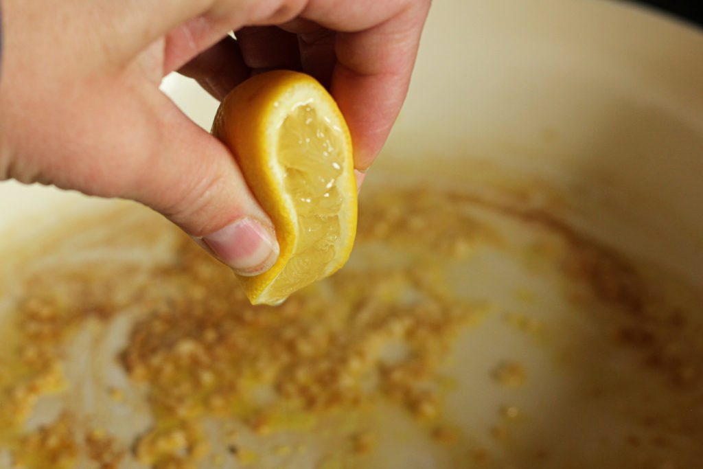 squeezing lemon into pan