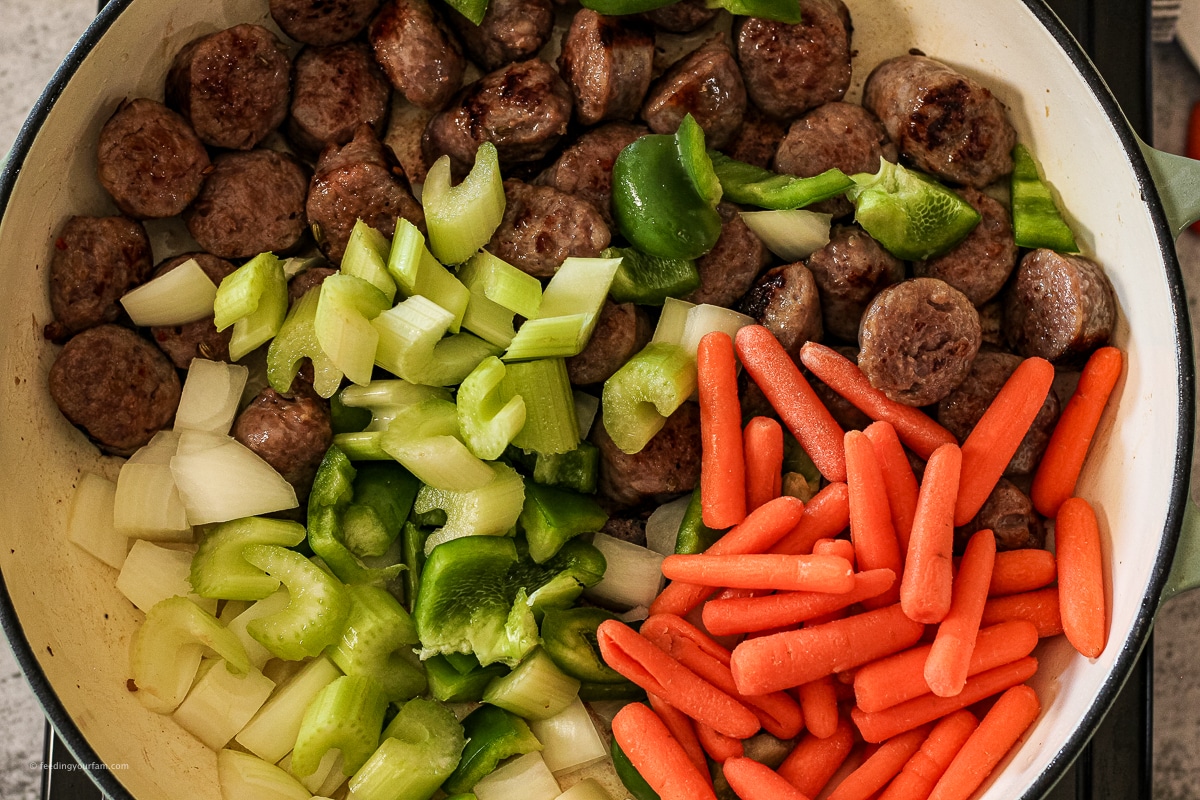 mixed vegetables with sliced Italian sausage in a large pan