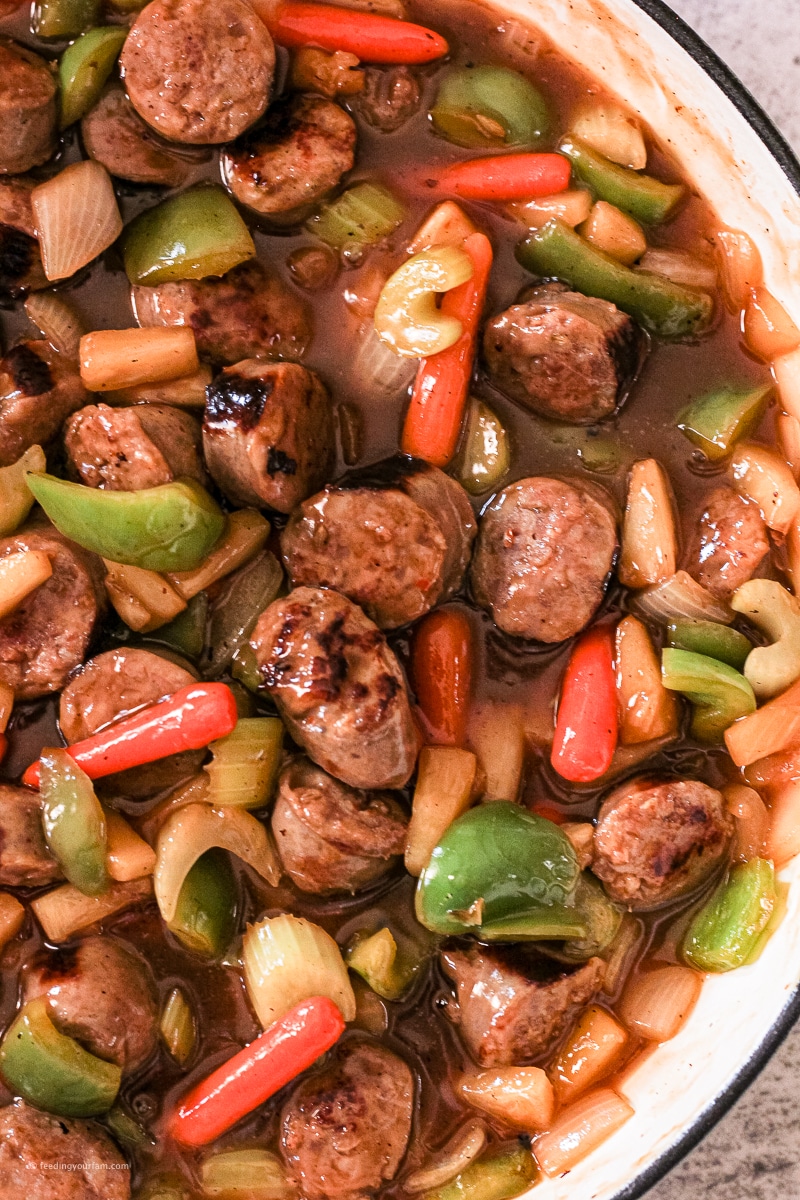sliced up pieces of sausages with vegetables and in a sweet and sour sauce