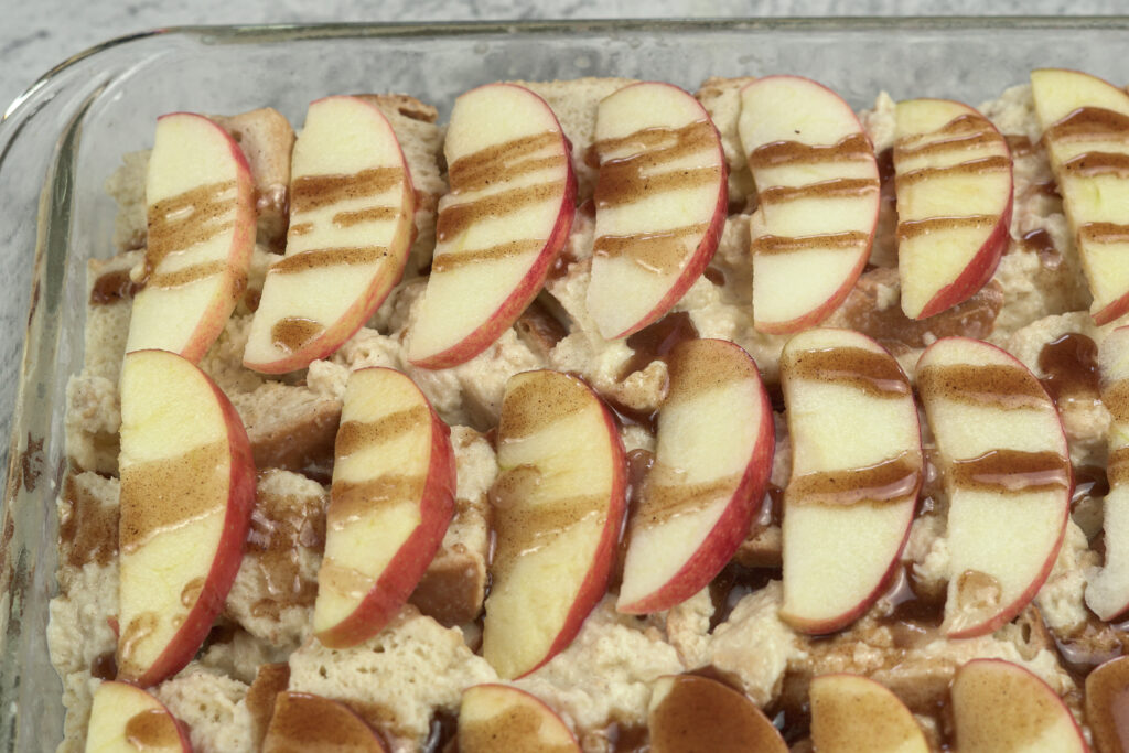 sliced apples on top of bread pudding