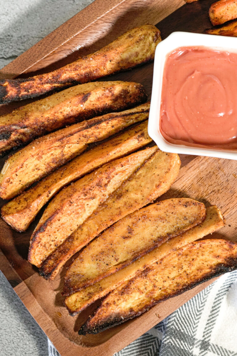 crispy air fried sweet potatoes on a wooden serving platter with dipping sauce