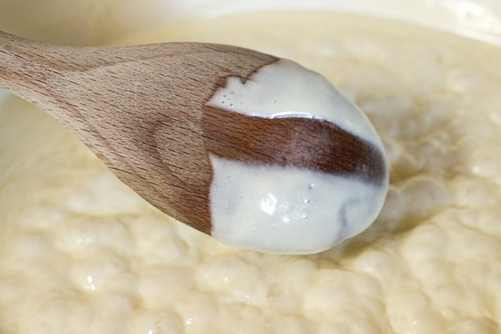 spoon of alfredo cream sauce showing thickness