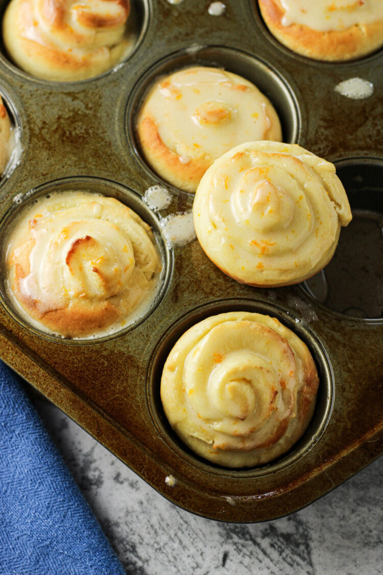 orange rolls in a muffin tin