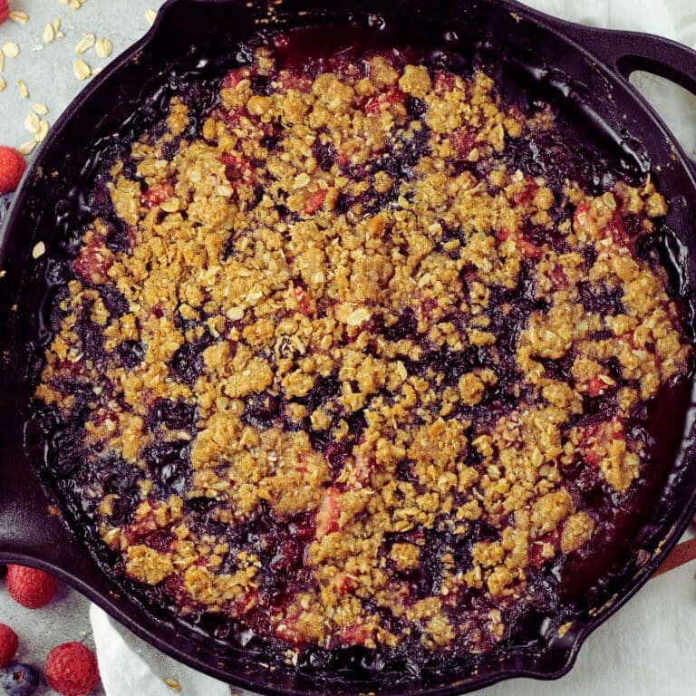 triple berry crisp baked in a cast iron skillet