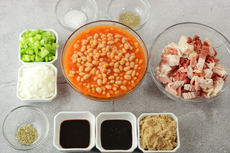 ingredients for baked beans in little bowls. Beans, bacon, brown sugar, green peppers, onions, salt and pepper. Oregano, molasses, Worcestershire, brown sugar