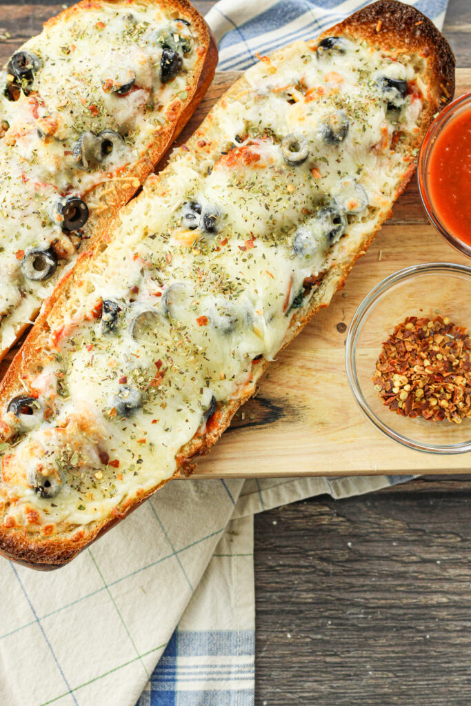 stuffed french bread pizza halves on a wooden platter