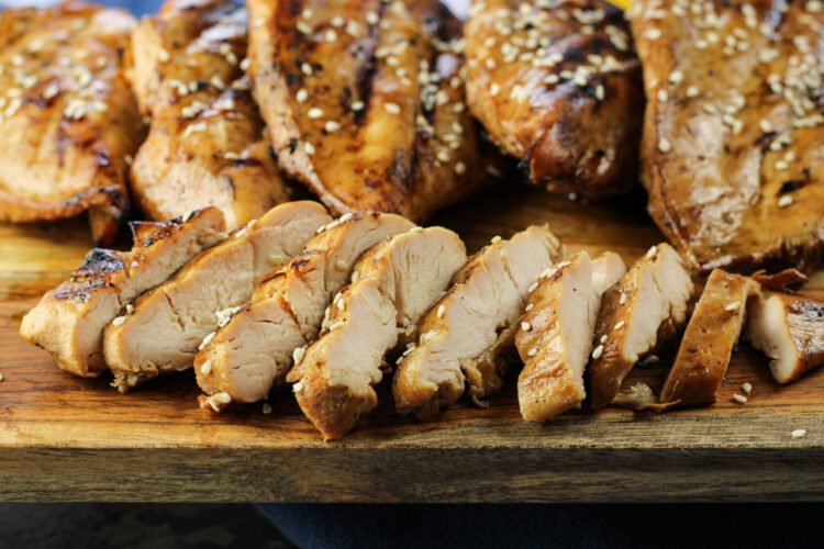sliced chicken breast on a wooden platter