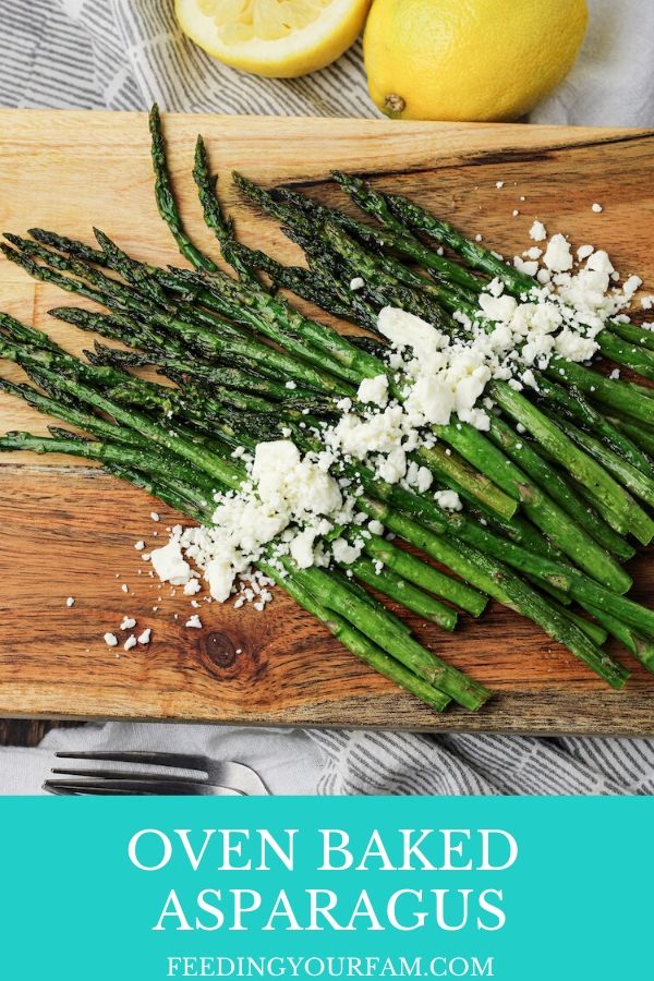 asparagus on a wooden platter sprinkled with feta cheese