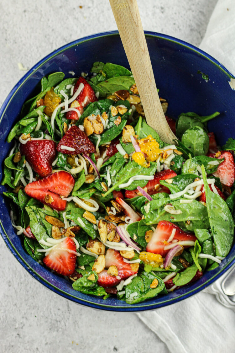 strawberry spinach salad in a blue salad bowl