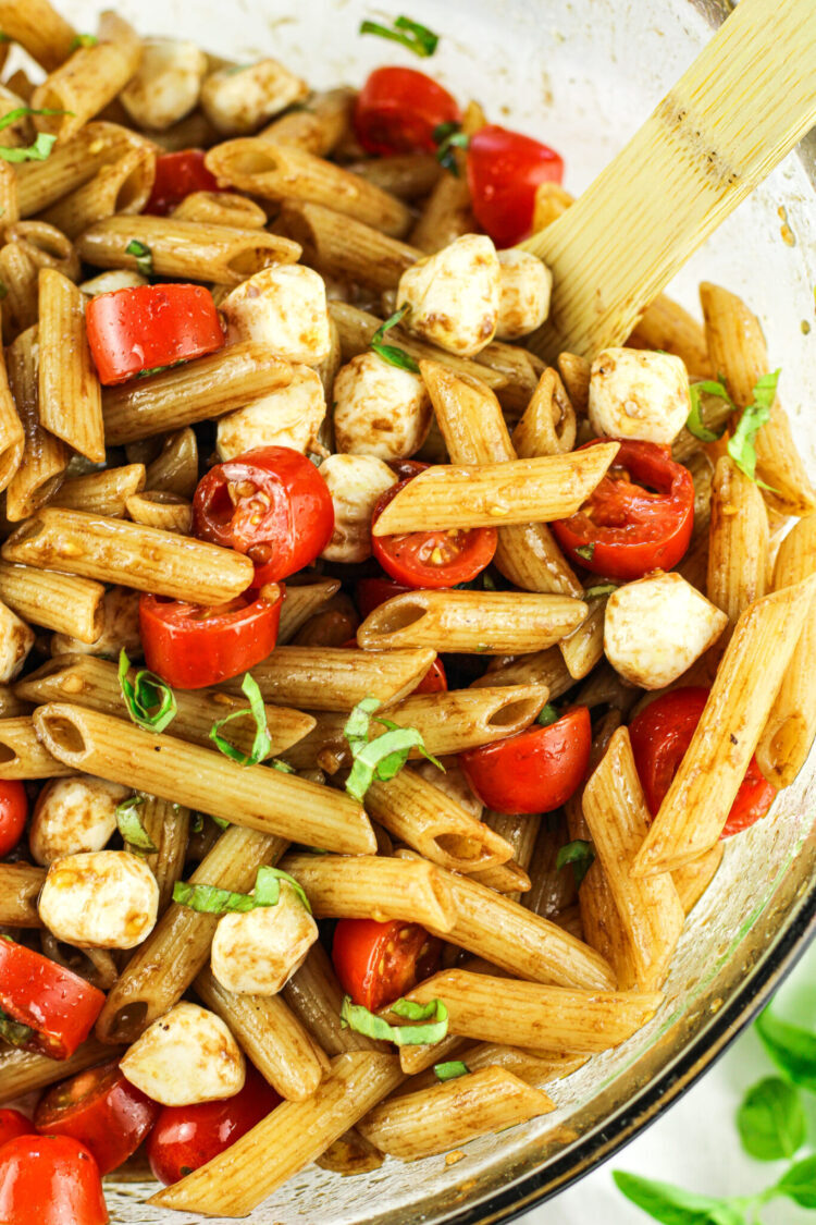 penne pasta with mozzarella pearls, tomatoes and basil in a balsamic dressing