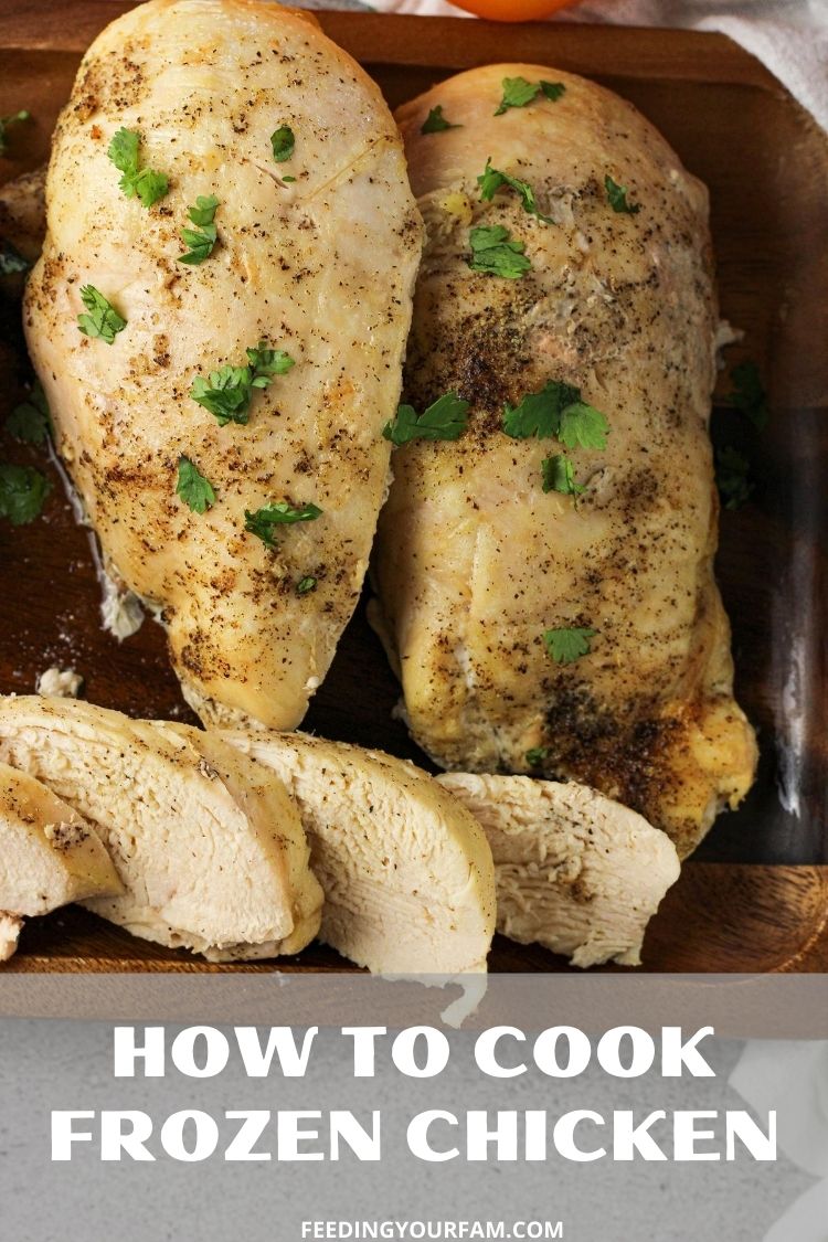 cooked chicken breasts on a wooden platter with chopped parsley sprinkled on top