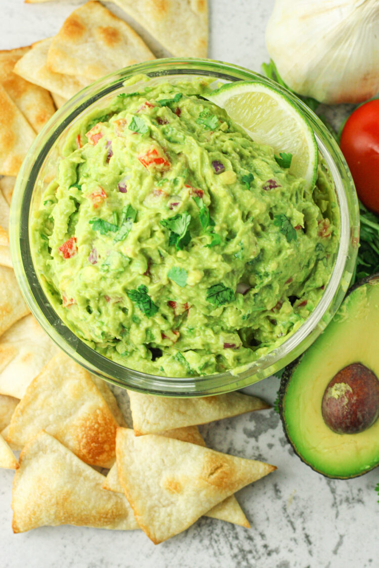 guacamole surrounded by chips and avocado