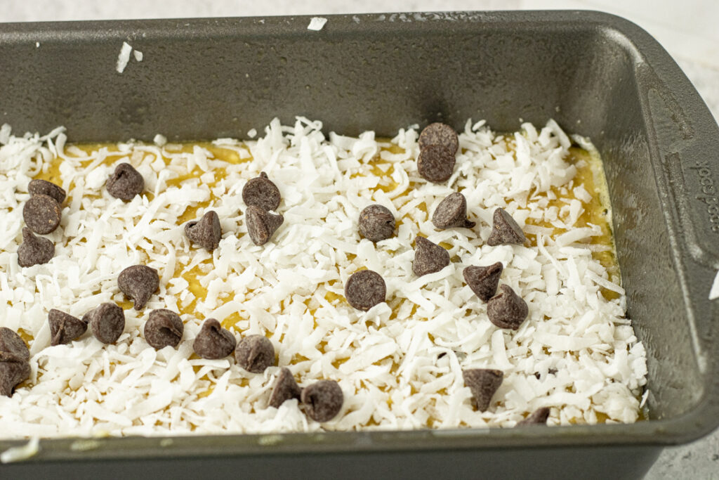 banana bread topped with coconut and chocolate chips in a pan