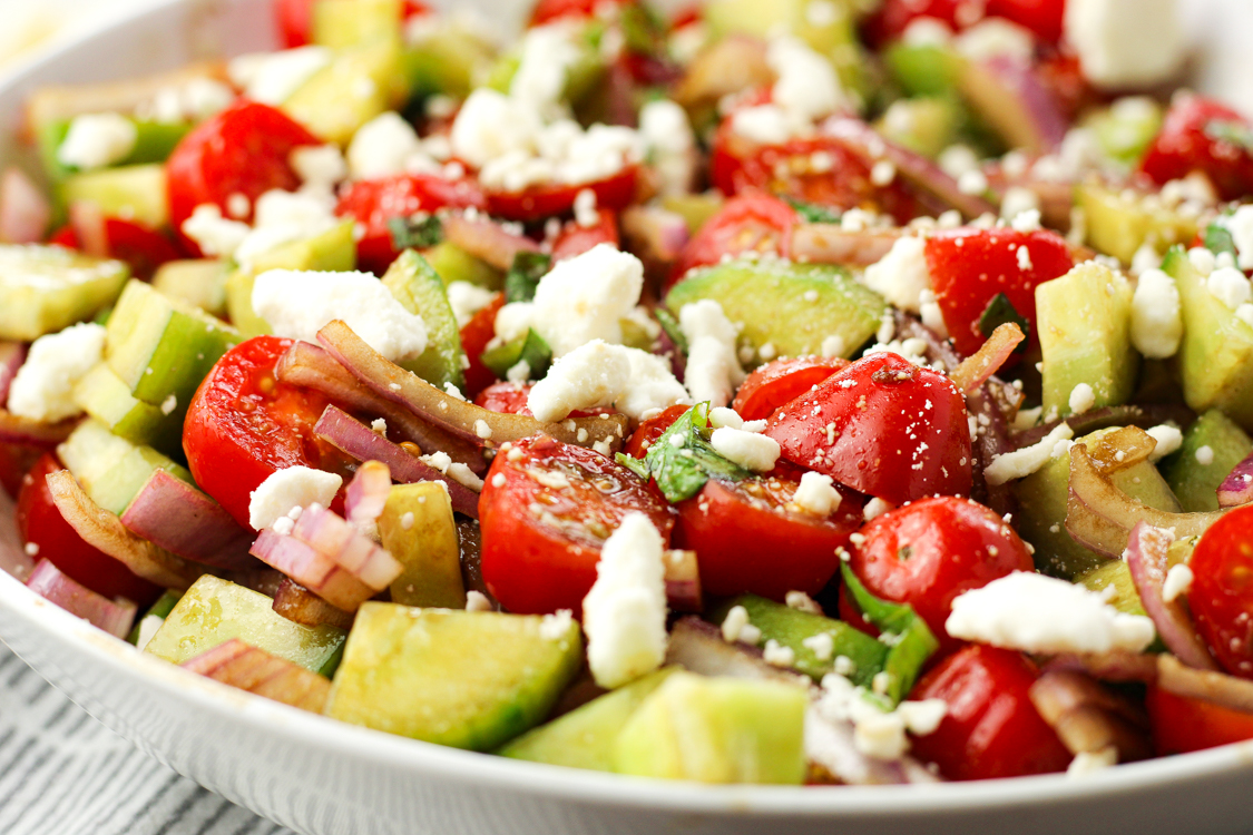 tomato cucumber feta salad in a white bowl