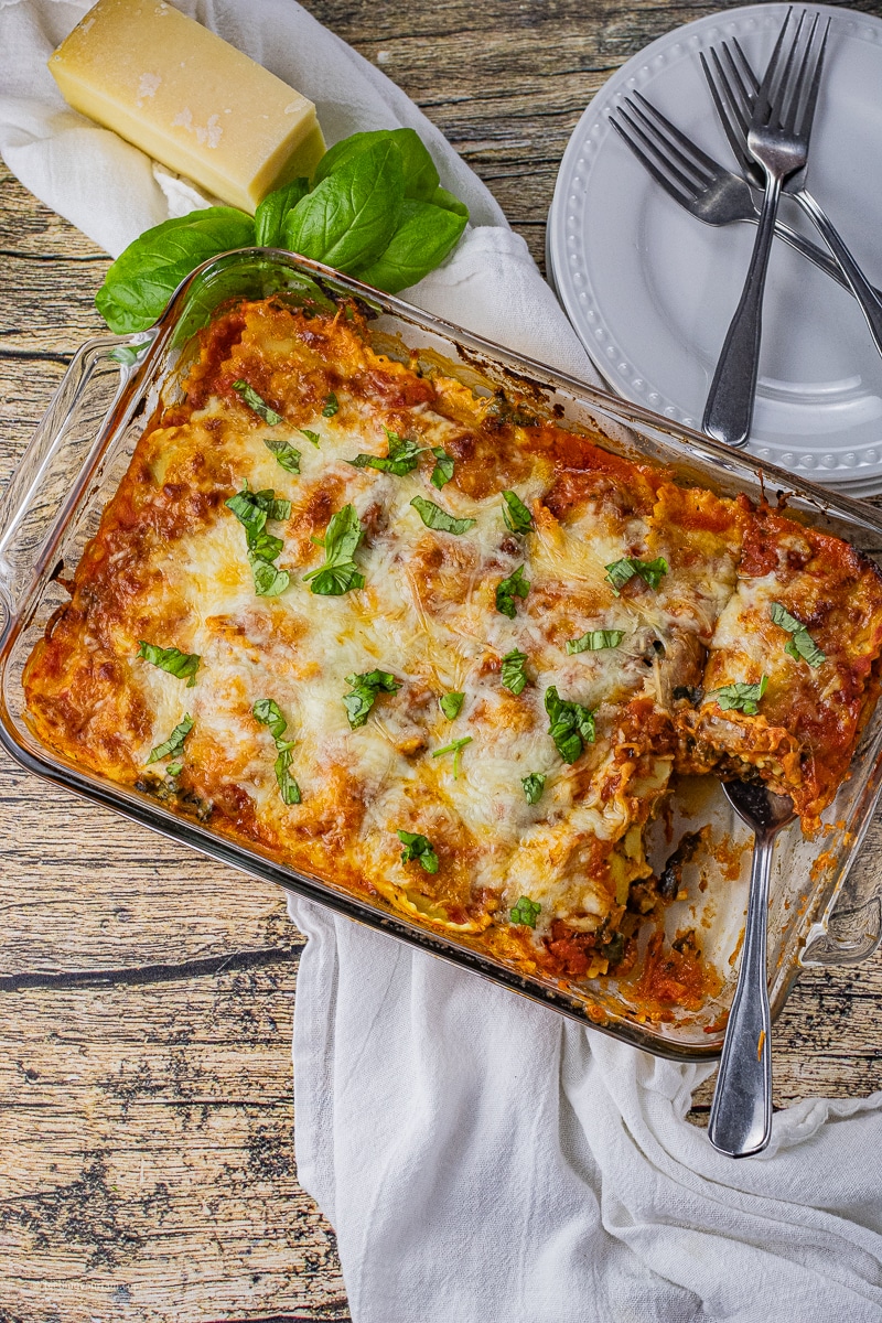 lasagna made with ravioli in a baking dish with some scooped out with a spoon