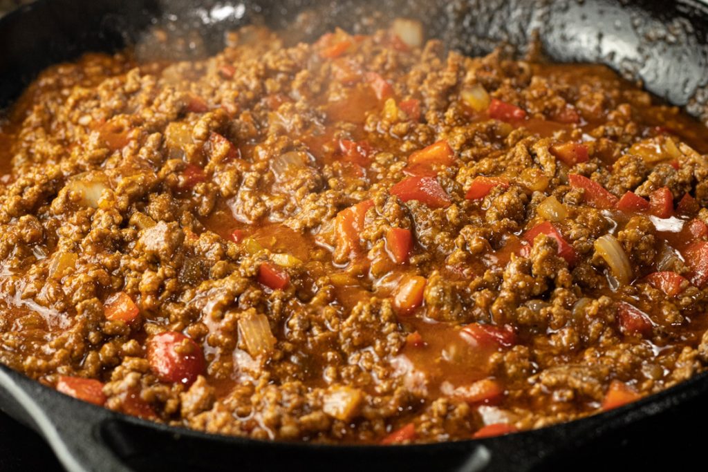 simmering pan of ground beef, onions, peppers and tomato sauce to make sloppy joe recipe