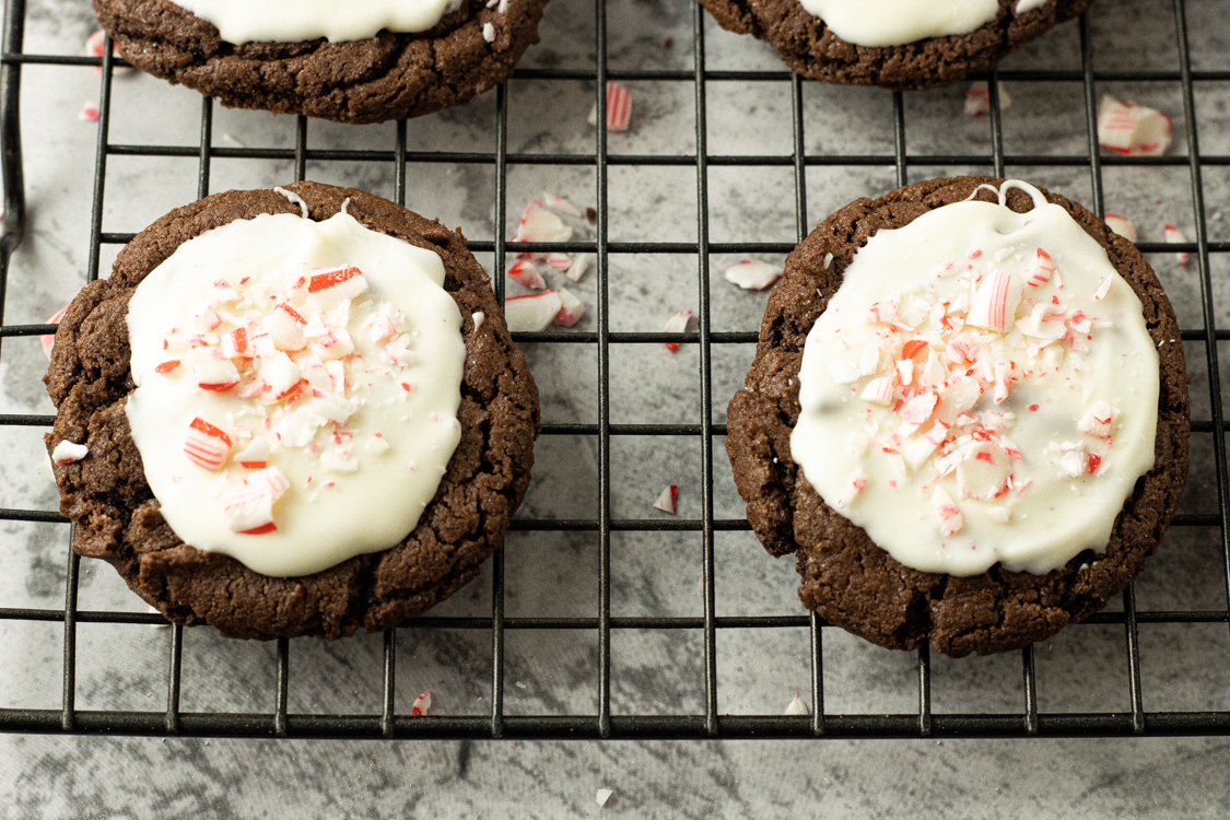 chocolate cookies topped with white chocolate and crushed candy cane