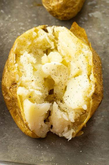 baked potato split in half with melting butter