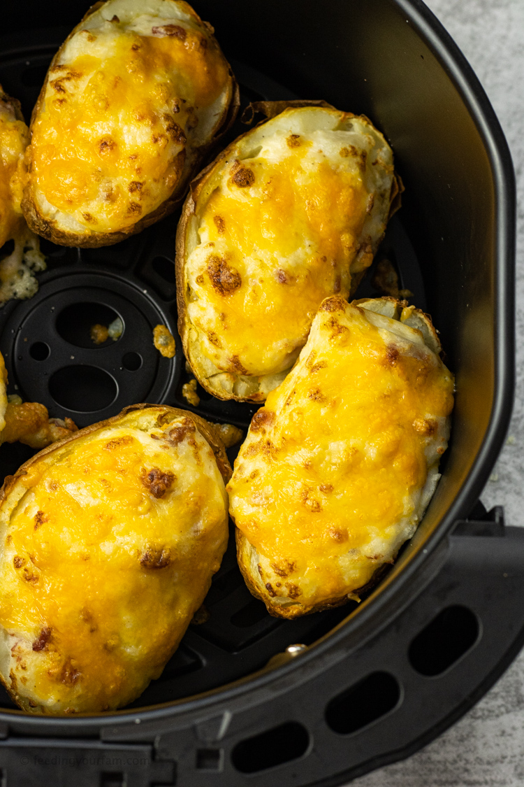twice baked potatoes with melted cheese in an air fryer basket