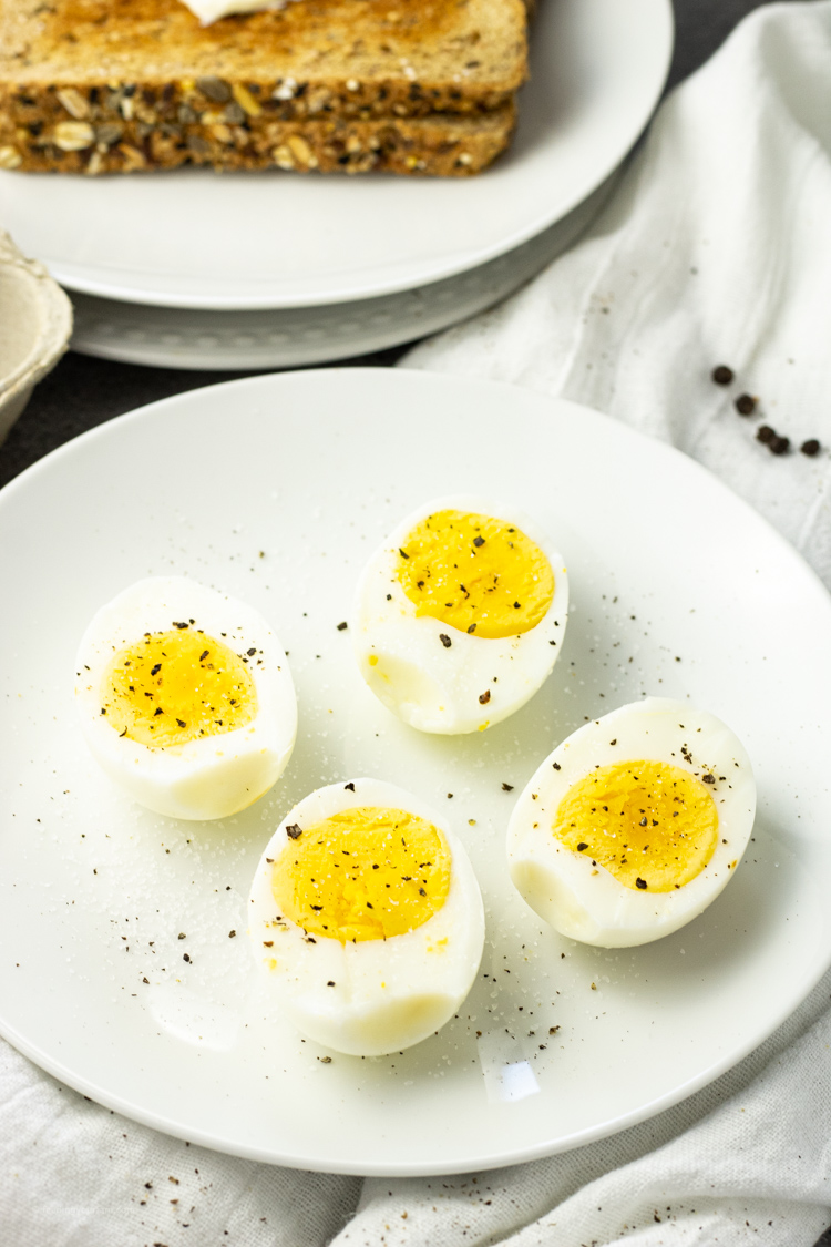 hard boiled eggs that have been cooked in an air fryer, sliced in half on a white plate