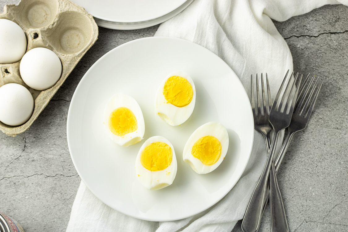 air fried hard boiled eggs sliced in half on a white plate