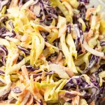 bowl of shredded cabbage, carrots and onions in a simple coleslaw