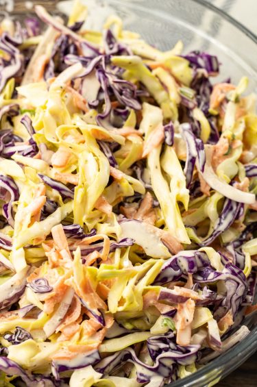 bowl of shredded cabbage, carrots and onions in a simple coleslaw