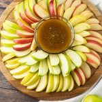 sliced apples surrounding dipping sauce made of caramel