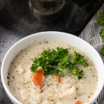 bowl of chicken soup with rice topped with parsley