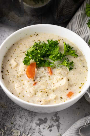white bowl filled with chicken and rice soup with cream