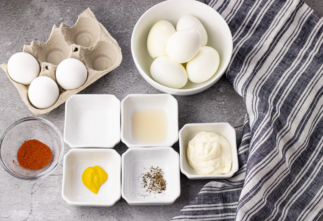 ingredients for deviled eggs in small white bowls