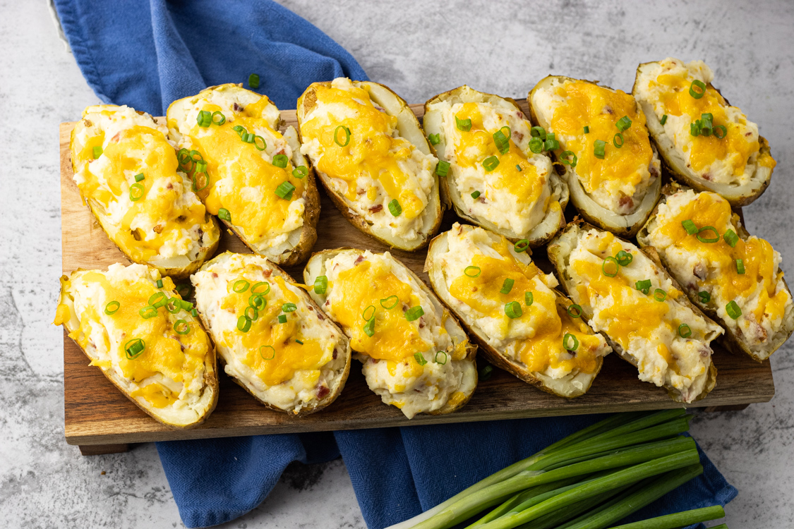 twice baked potatoes on a wooden platter