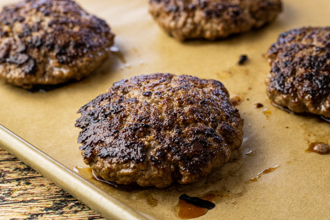 cooked hamburger on a piece of brown parchment paper