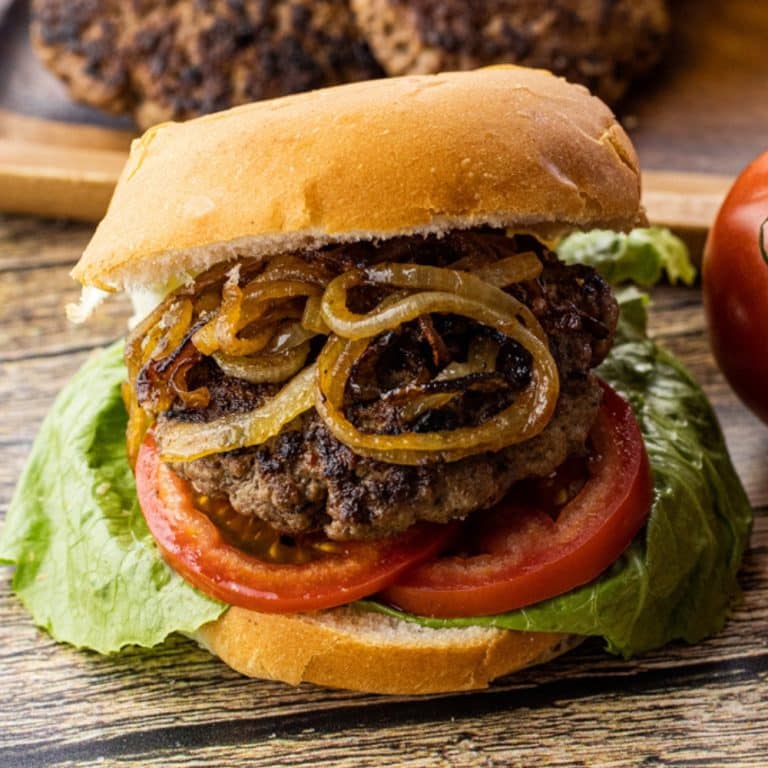 hamburger in a bun with fried onions, tomato and lettuce