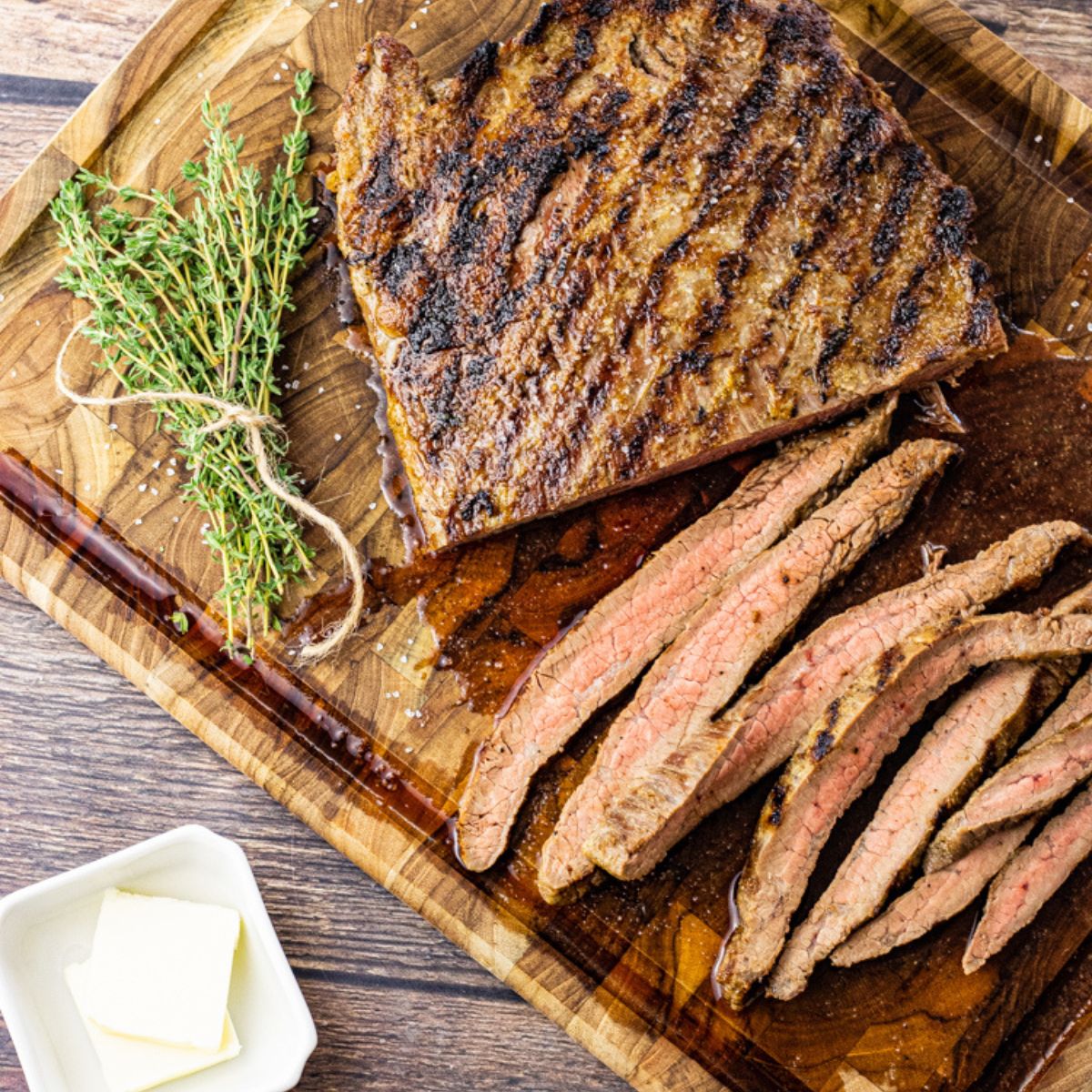 sliced flank steak on a wooden cutting board