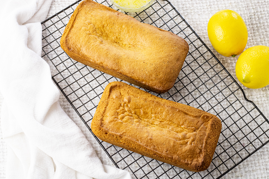two lemon bread loaves on a cooling rack