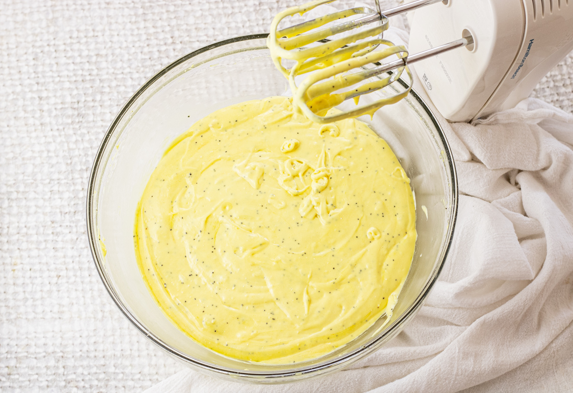 yellow lemon loaf with poppyseeds batter in a glass mixing bowl