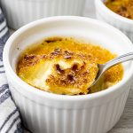 spoonful of creme brulee from a small white ramekin