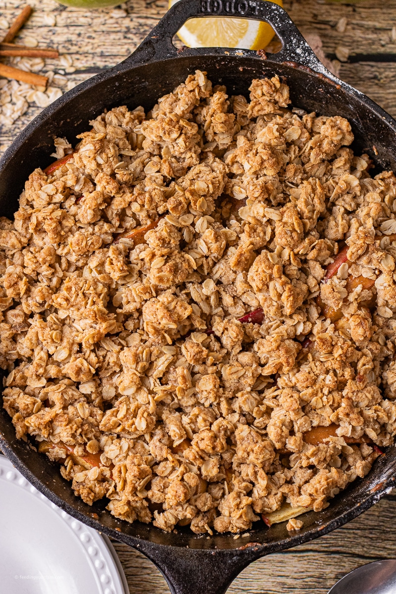 simple apple crisp with soft apples and crisp oatmeal cookie like topping baked in a cast iron skillet.